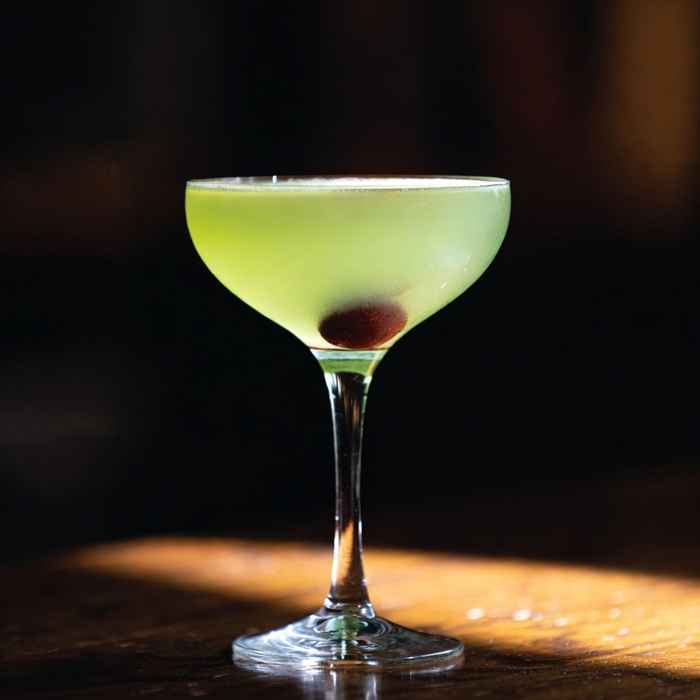 매혹적인 연녹색 액체와 체리 장식이 돋보이는 라스트 워드 칵테일 완성 사진