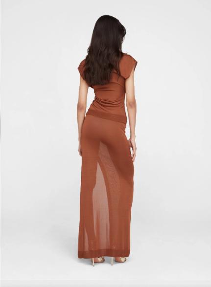 브라운 컬러의 니트 롱 스커트를 뒷모습에서 착용한 모습, 몸매 라인이 강조된 시스루 실루엣