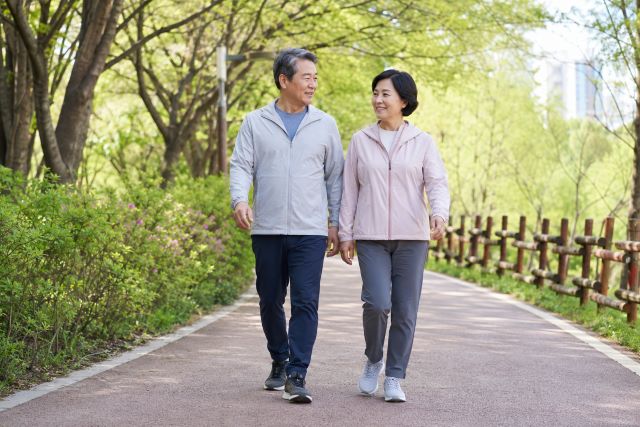 공원 산책로를 함께 걷는 60대 부부