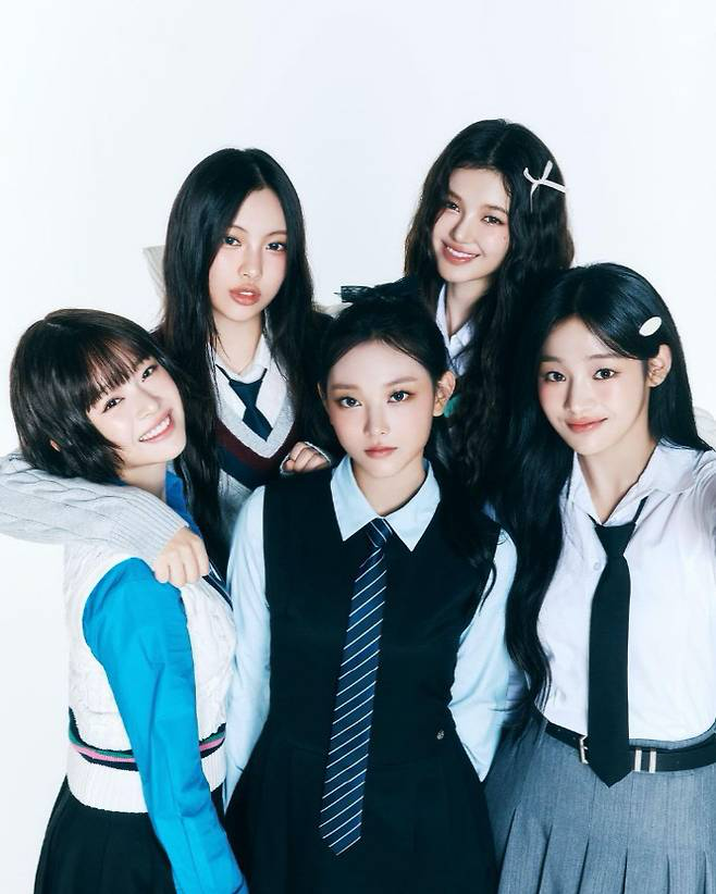 뉴진스 멤버들이 교복 콘셉트로 촬영한 사진. 논란 속에서도 그들의 순수한 매력은 여전히 사랑받고 있다.