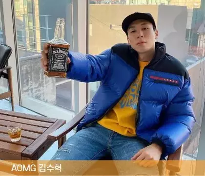 에이오엠지 김수혁 대표가 앉아서 술병을 들고 있는 모습