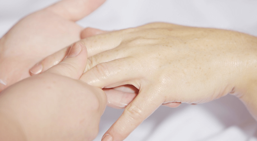 손이 저리는 이유로 손 전체 마사지를 받고 있는 모습