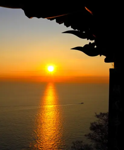 어두운 바닷가 태양이 떠오르면서 주변이 붉게 물든 모습