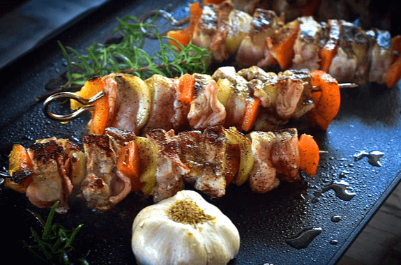 네모난 프라이팬에 꼬치 3개가 있다. 소고기와 당근, 감자와 섞여진 모습이다.