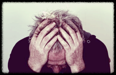 두통으로 머리를 두손으로 감싸고 있는 남자