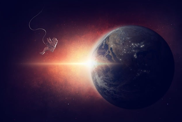 우주에 떠 있는 지구와 우주비행사 이미지