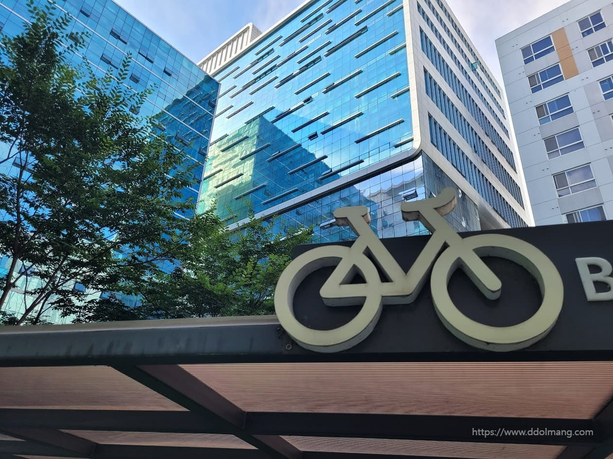 회사 내 자전거 주차장의 자전거 형상과 회사 건물