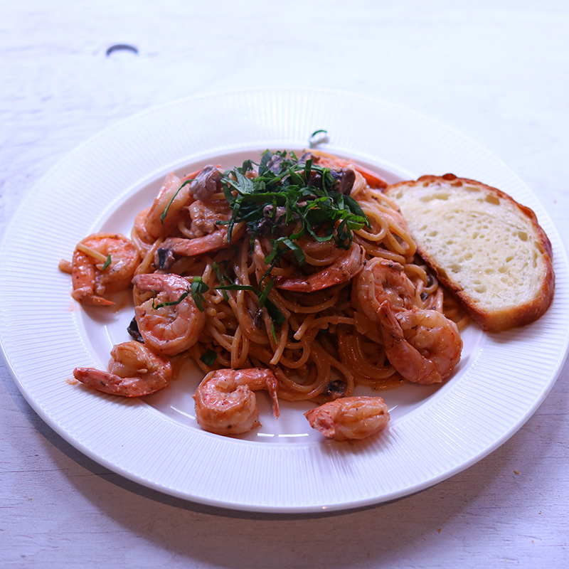 카라멜라이즈 어니언 갈릭 로제 소스 새우 스파게티 흰색 접시에 담겨 토스트 한개와 셋팅