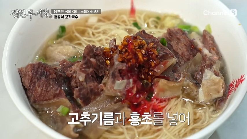 홍콩 고기국수에 고추기름과 홍초를 넣고 있는 모습