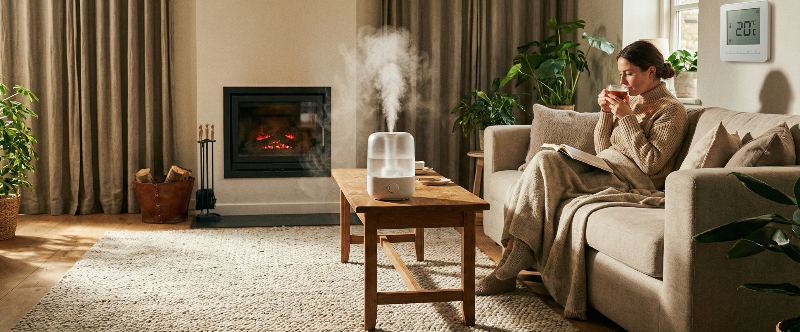 따뜻한 겨울 실내에서 가습기와 담요로 난방비를 절약하는 모습