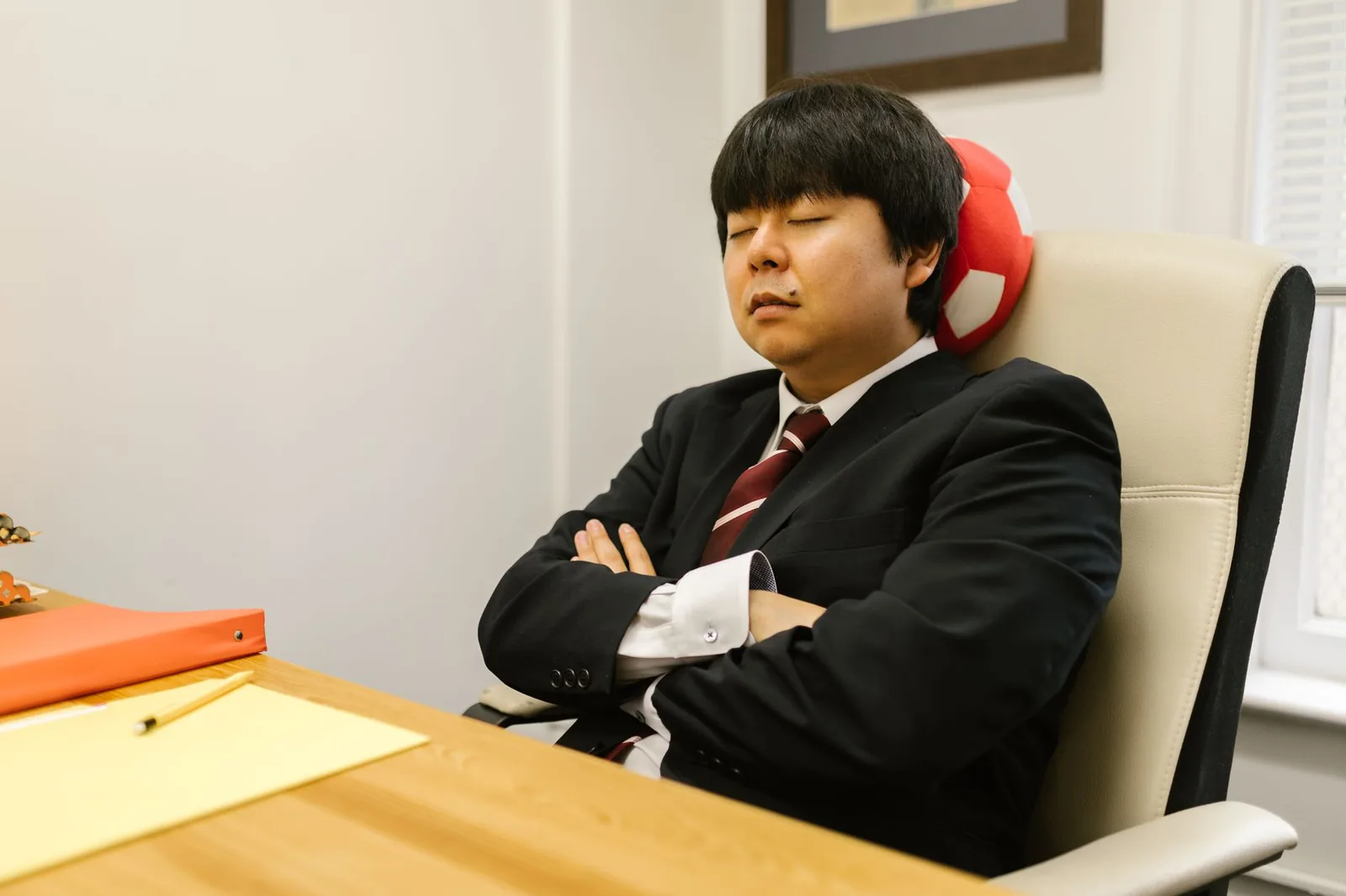 검은색 정장 차림의 사업가가 사무실에서 눈을 감고 휴식 중입니다. 업무 중의 휴식.