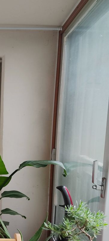 체리색 시트지가 남아있는 베란다 샷시 사진