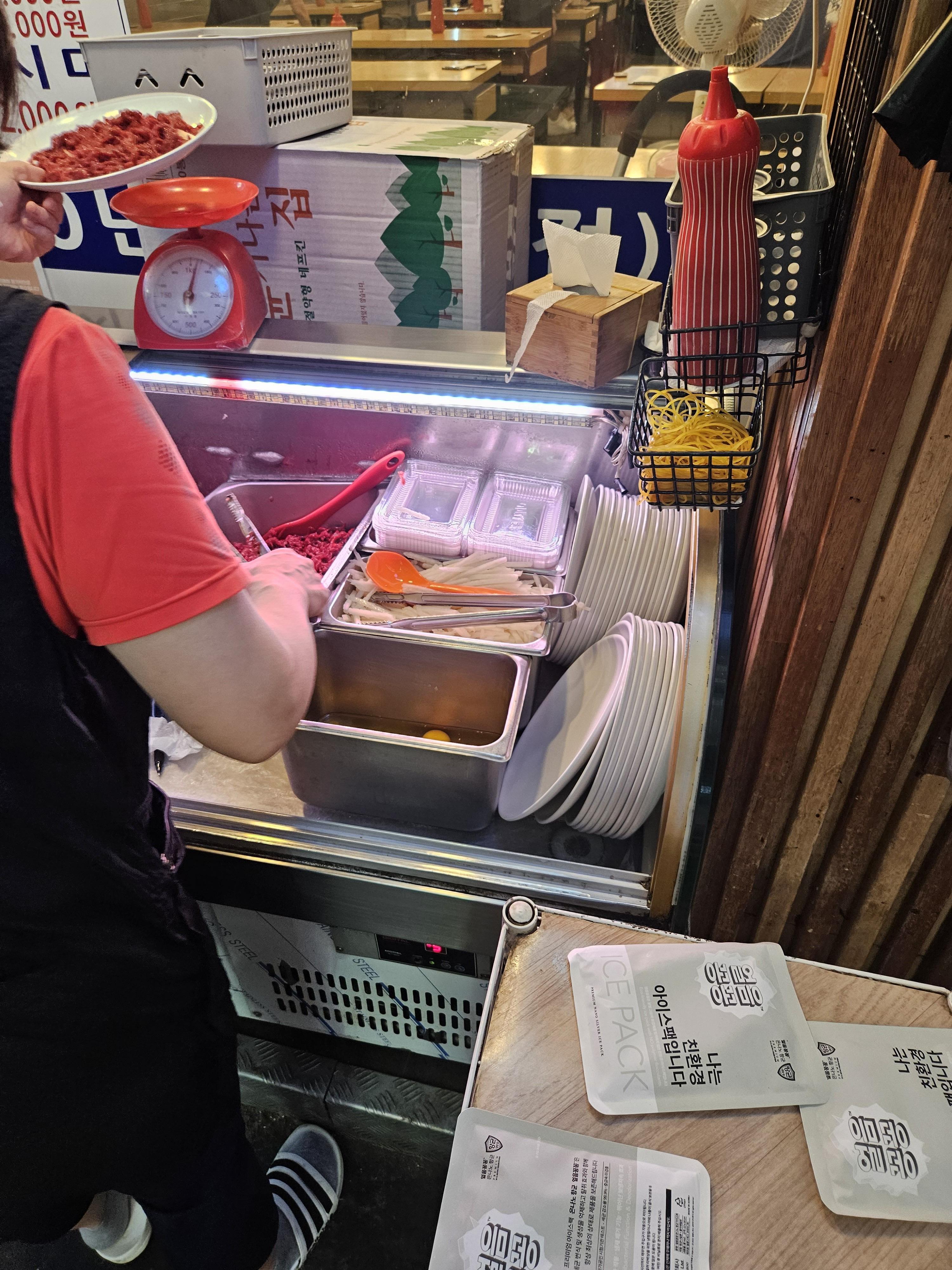 창신육회 주방이모가 육회 무게를 재는 모습