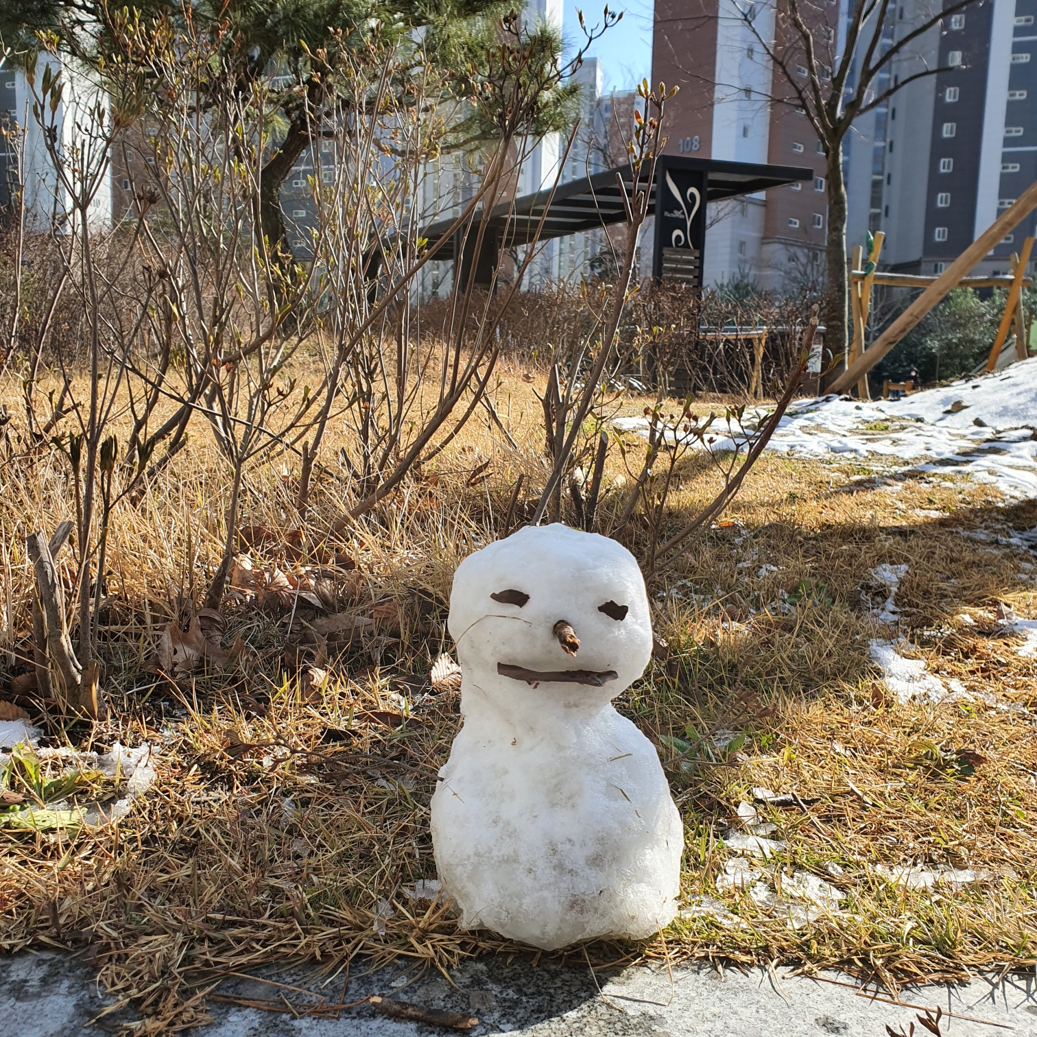 잔디 화단 앞에 있는 눈사람