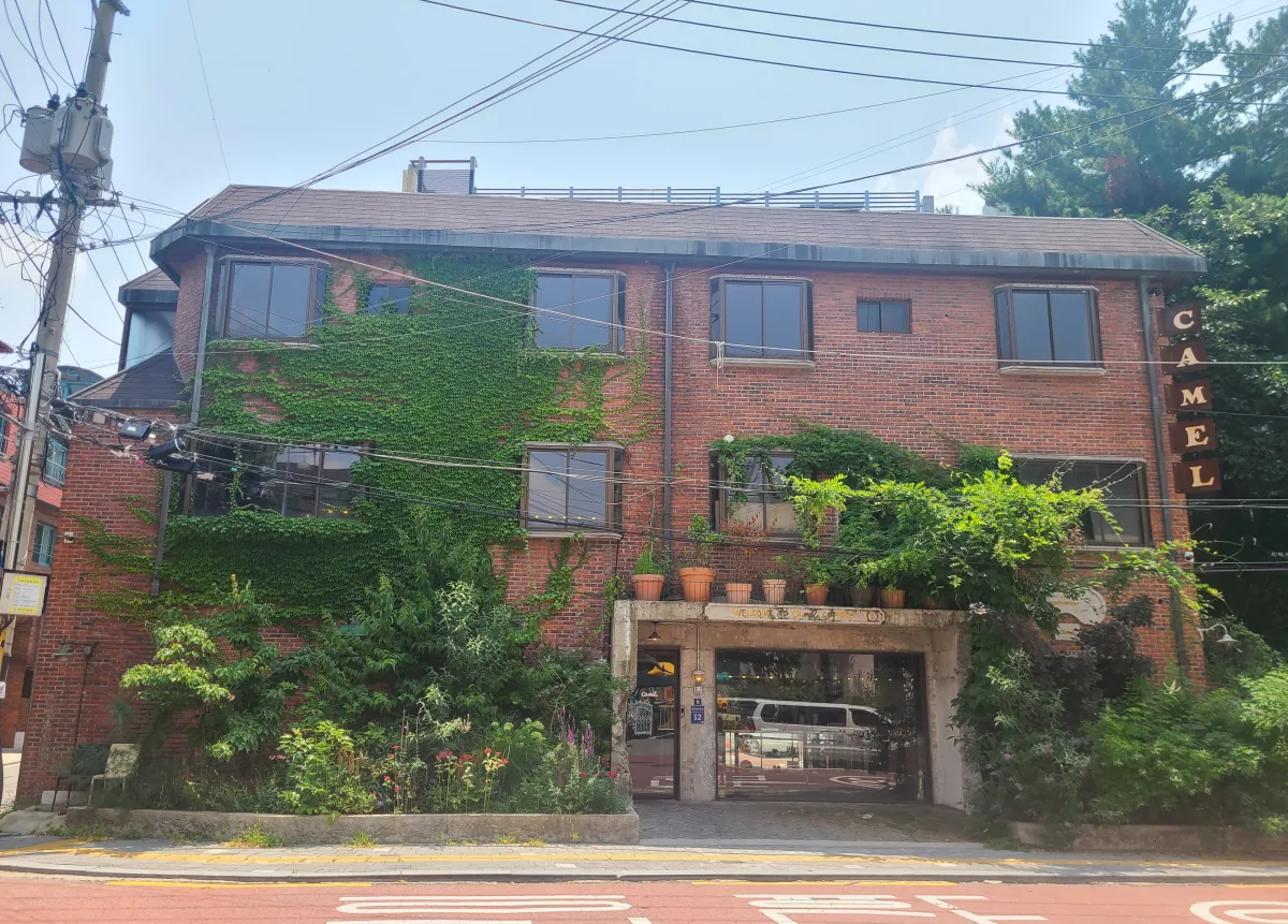 카멜커피상도점-외부건물모습-나무로둘러싼-빨간벽돌건물