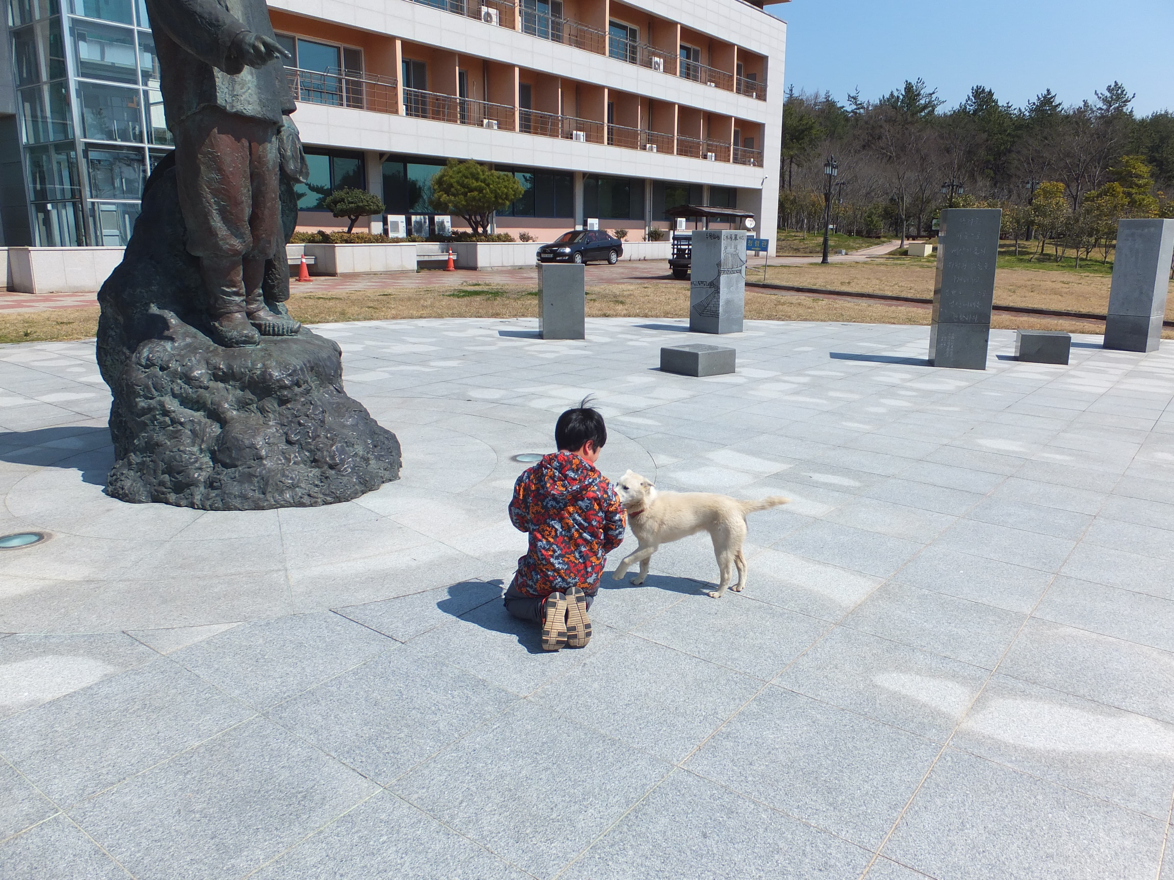 동상 앞 똘망이 옆의 강아지