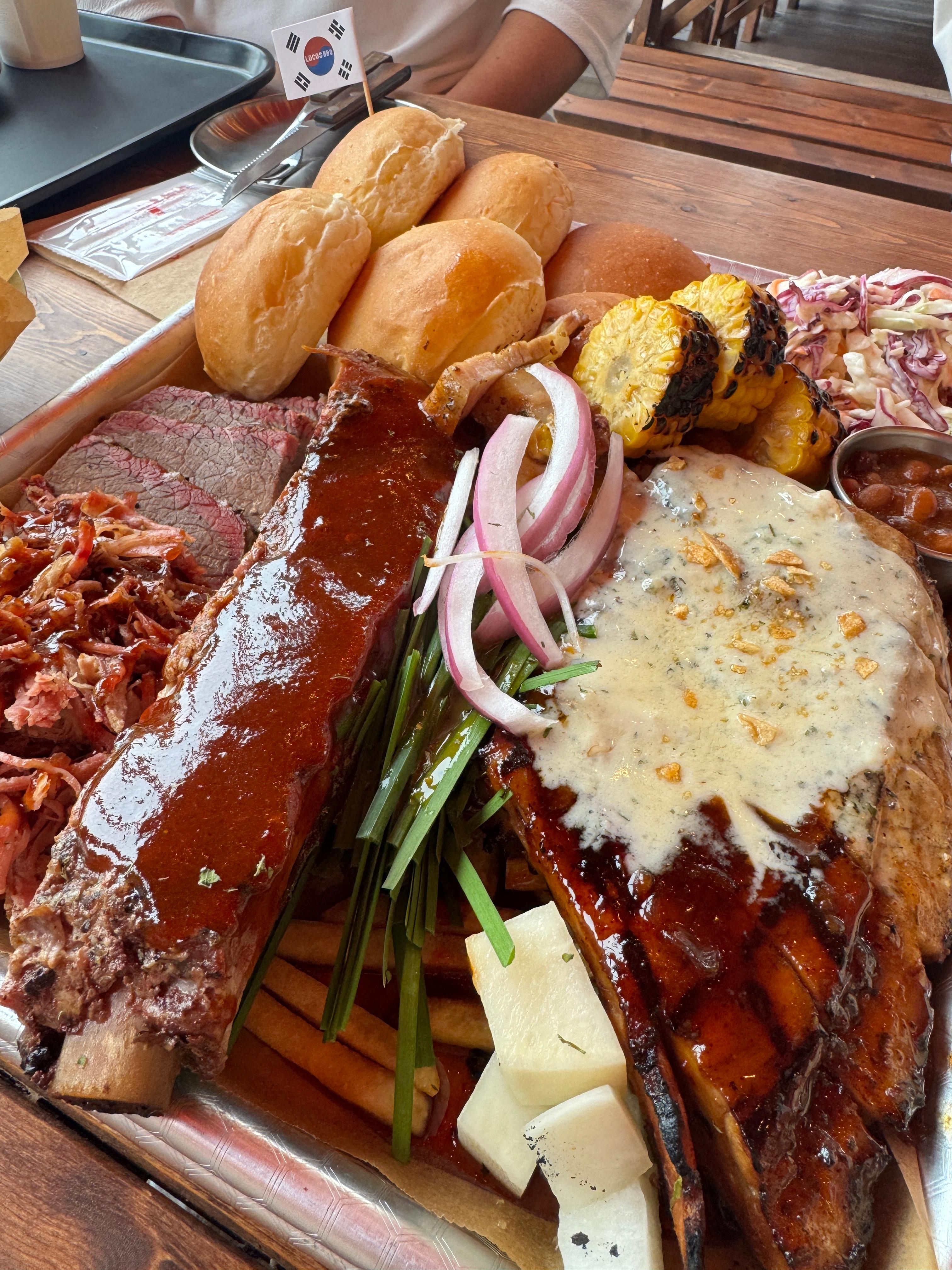 로코스바비큐 남양주점 로코스 샘플러 구성. 큰 쟁반에 바베큐, 빵, 구운 야채, 옥수수, 소스등이 맛깔스럽게 세팅되어 있는 실제 식사 사진