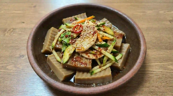 식탁 위에 도토리묵 무침이 놓여 있음