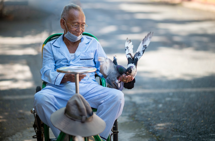 환자복을 입고 앉아있는 남성의 사진