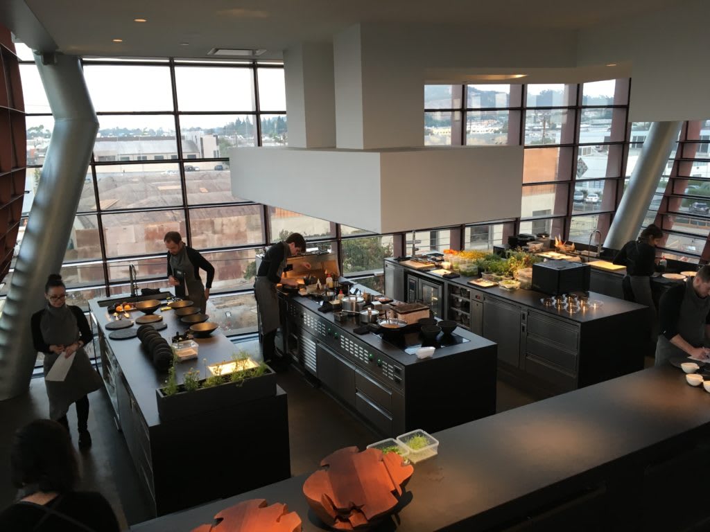 Interior view of Vespertine restaurant's modern kitchen in Los Angeles with chefs preparing dishes in a bright, spacious setting