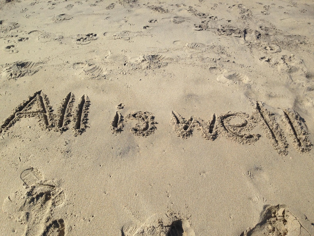 AII IS WELL 이라고 모래사장에 쓰여있는 사진