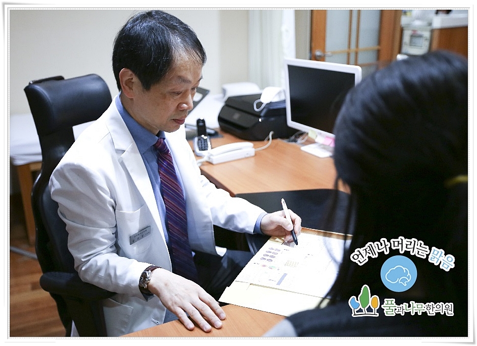 차트를 보며 진료 중인 한의사의 모습