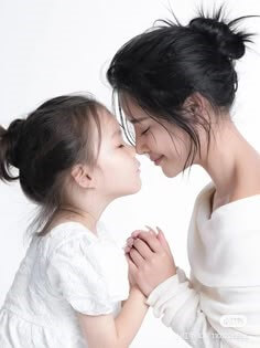 하얀-옷을-입은-엄마와-딸이-토를-맛대고-미소짓는-모습