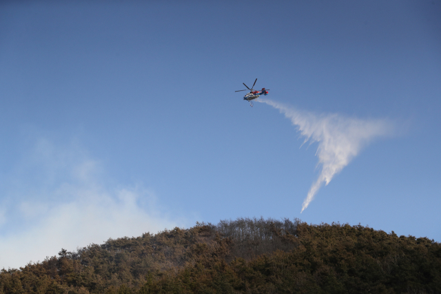 헬기를 동원하여 산불을 끄고 있는 이미지