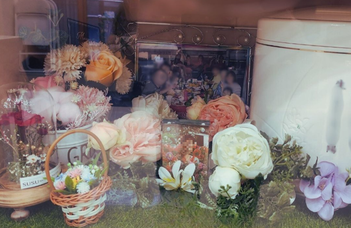 엄마의 사진과 꽃이 놓인 납골당 내부 유골함 - 따뜻하고 단정한 추모공간