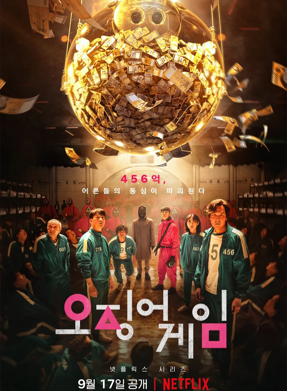 넷플릭스 시리즈 '오징어 게임'의 공식 포스터. 초록색 운동복을 입은 참가자들이 어두운 공간에 서 있고, 그들 머리 위로 막대한 상금이 가득 담긴 거대한 황금색 돼지 저금통이 매달려 있다. 배경에는 분홍색 작업복을 입은 관리자들과 가면을 쓴 인물이 보이며, 하단에는 '오징어 게임'이라는 제목과 공개일 정보가 적혀 있다.