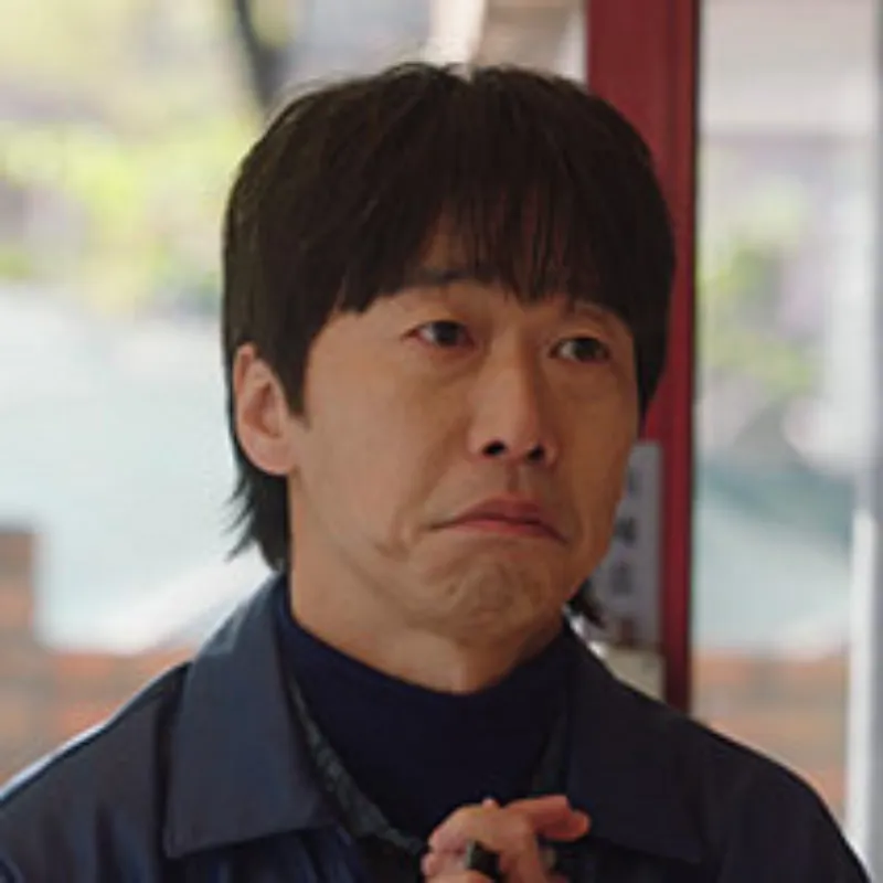 어느 실내를 배경으로 검은 옷을 입고 울것 같은 표정의 이상해