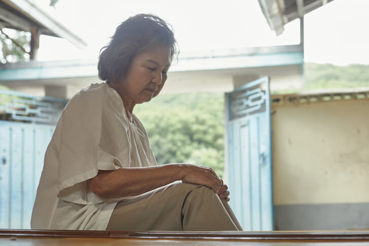 근심이 많아 보이는 표정으로 앉아있는 노인