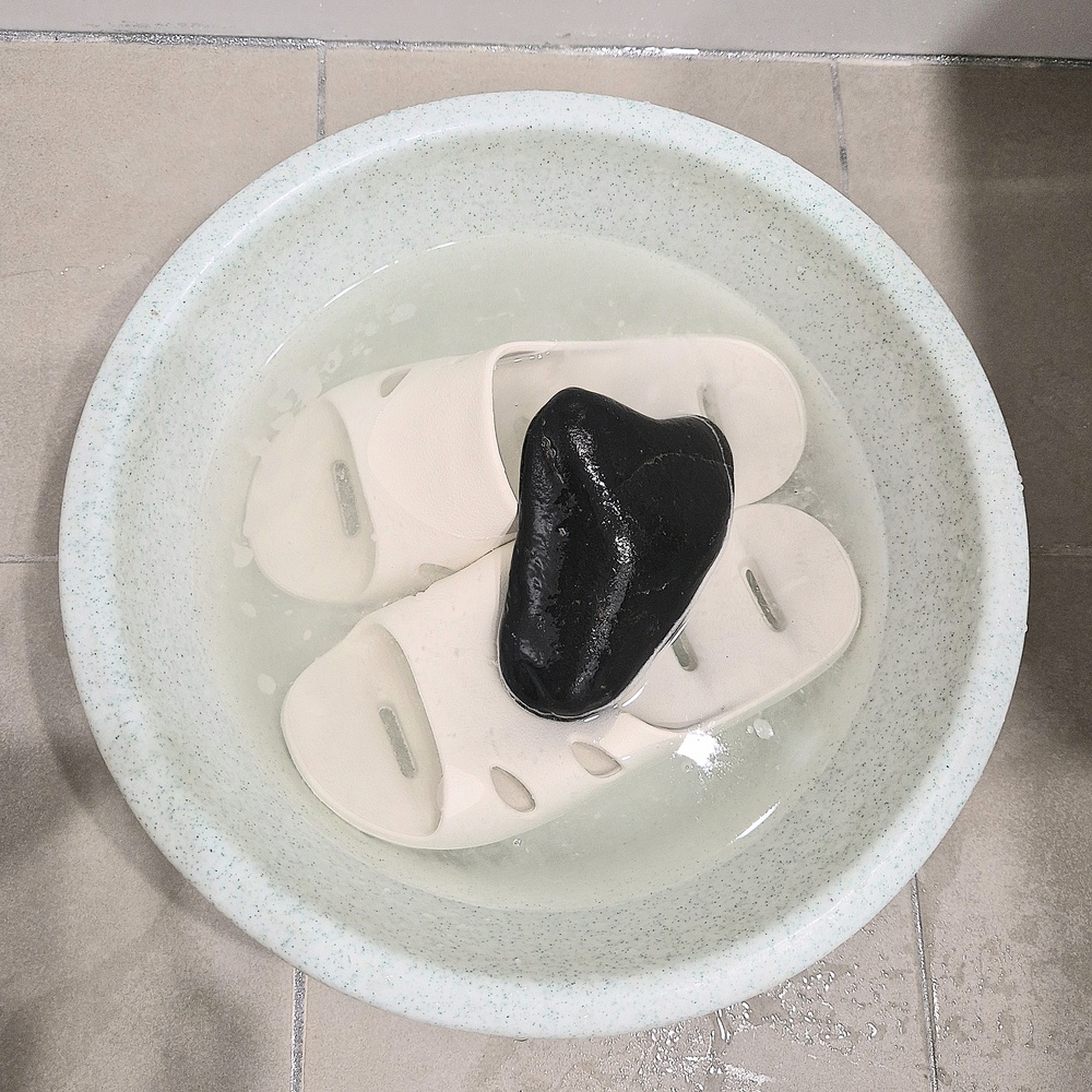 과탄산소다를 활용해 욕실화를 대야에 담가 세척하는 모습