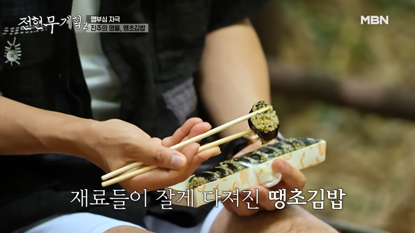 전현무계획2에 소개된 진주 편에서 전현무가 포장 용기에서 땡초김밥 하나를 젓가락으로 집어올린 모습