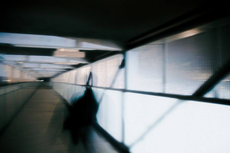 A moody, blurred hallway with abstract shadows and indoor lighting.