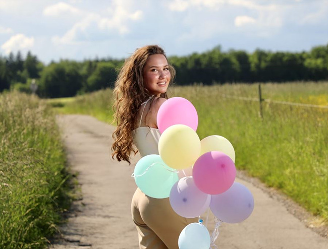 풍선을 들고 환하게 웃는 여자 사진,출처: unsplash 제공