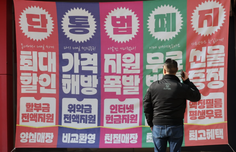 단통법폐지 홍보물을 보는 남자의 뒷모습 (사진 출처:연합뉴스)