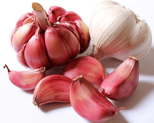 붉은색 계열 껍질을 가진 2개의 통마늘과 하얀색 껍질을 가진 1개의 통마늘이 모여있다.