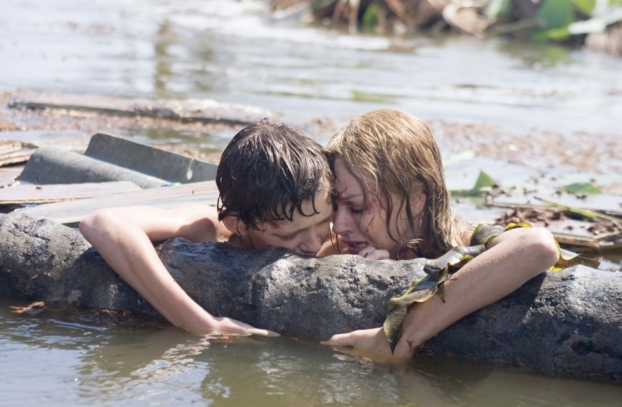 쓰나미에 휩쓸렸다가 다시 만난 엄마와 아들가 물에 떠 있는 통나무를 잡고 안도의 한숨을 쉬고 있다.