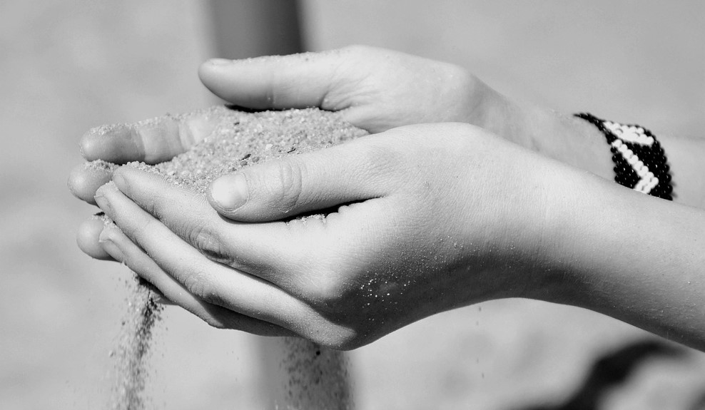 두 손을 모아 모래를 퍼 담았는데, 손 틈새 사이사이로 모래가 빠져나가고 있는 사진