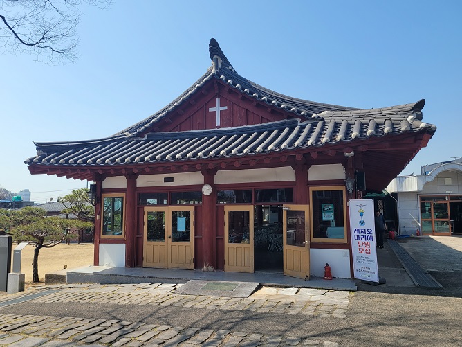 사진은 문산성당의 옛 한옥 성당 건물입니다. 잿빛 기와와 하얀 수막새가 대비를 이루어 단아한 매력을 자아냅니다.
현재는 식당 내지 회합실 등으로 사용하고 있으며 벽 위에는 역대 주임신부님들과 문산본당 출신 신부님들의 사진이 게시되어 있습니다.