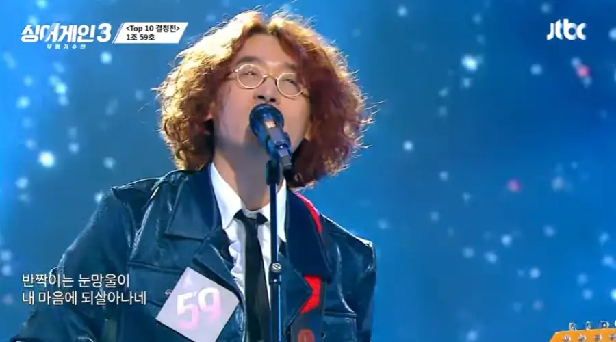 싱어게인3-
파란배경 무대 파란자켓 흰셔츠 넥타이 노란파마머리 금테안경을 쓰고 노래하는 59호