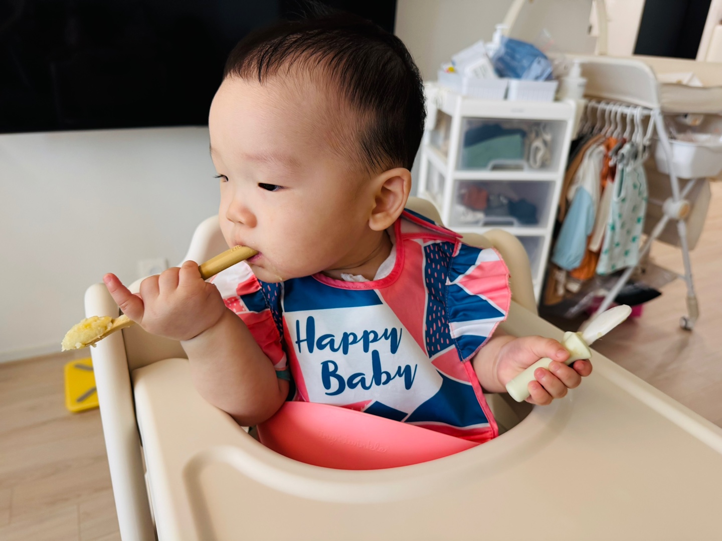 손에 든 숟가락으로 매시를 입에 넣으며 스스로 먹기를 시도하는 찬솔이