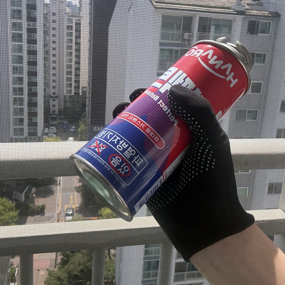 부탄가스 흔들어서 잔여 가스 확인하는 모습