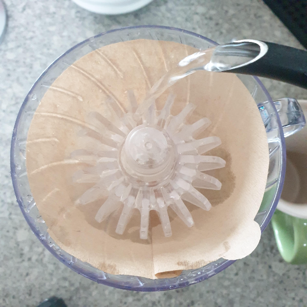 드리퍼 안에 황색 필터가 있고 린싱을 돕는 기구가 들어있다. 드립포트로 린싱하는 중