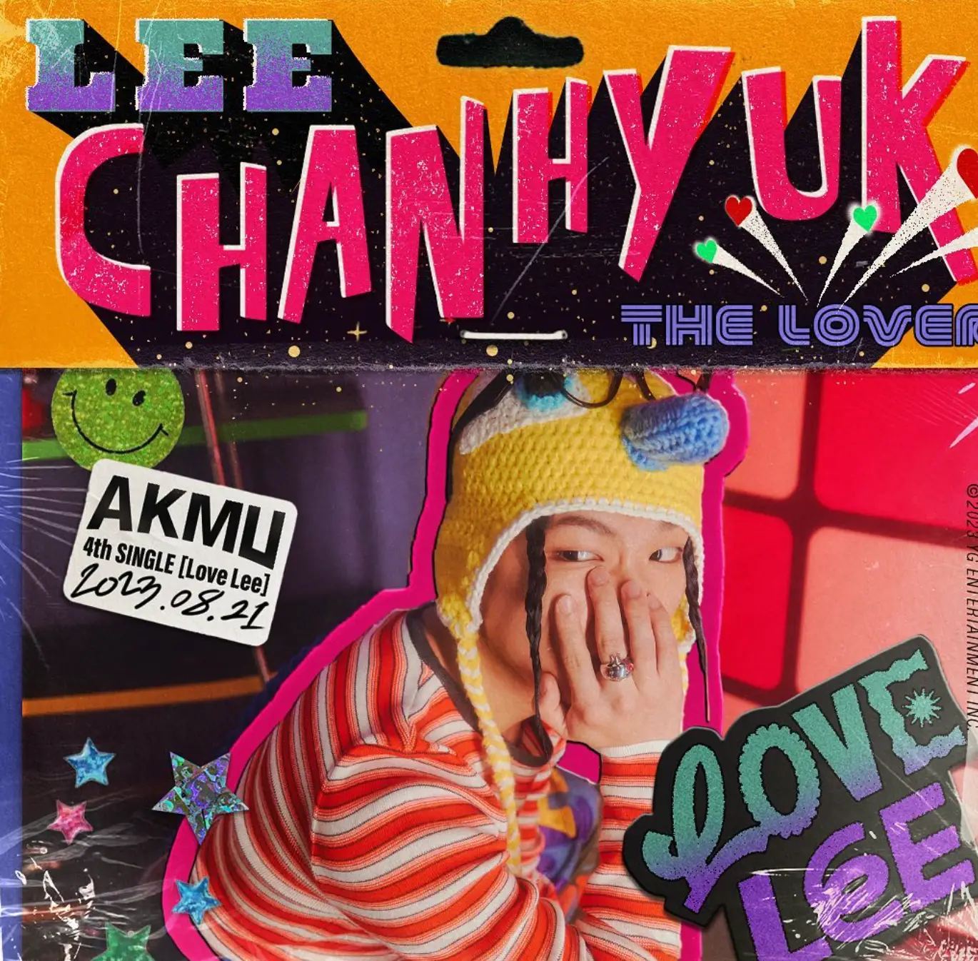 악뮤- 알록달록 쟈켓 위 찬혁이 노란색 모자에 주황색 스트라이프 티를 입고 턱에 손을 괸채 옆을 바라보는 모습