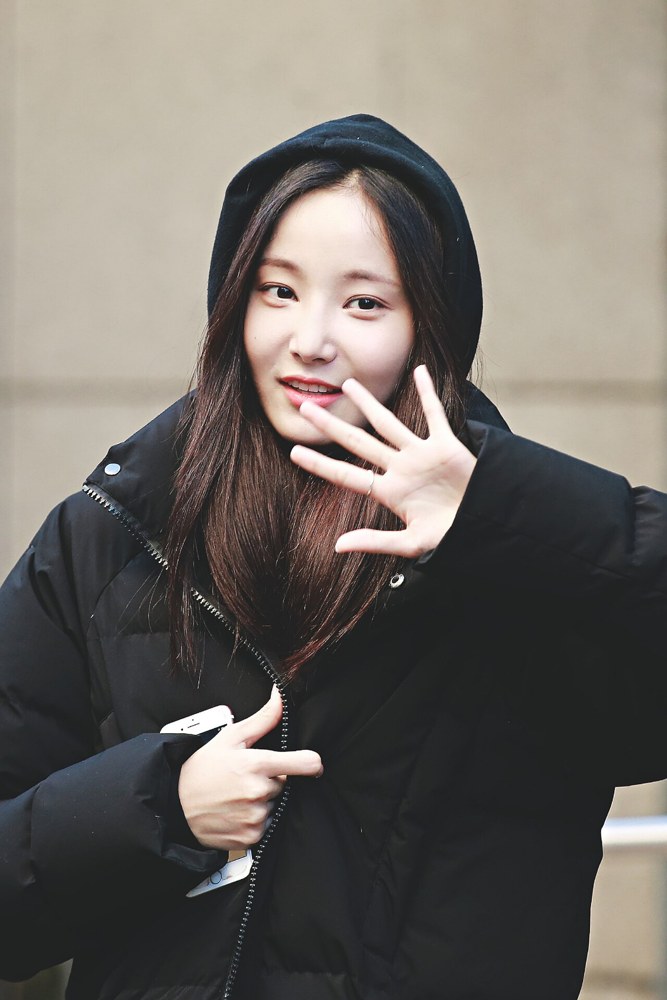 검은 패딩 후드를 쓴 연우가 손을 들어 인사하며 웃는 모습