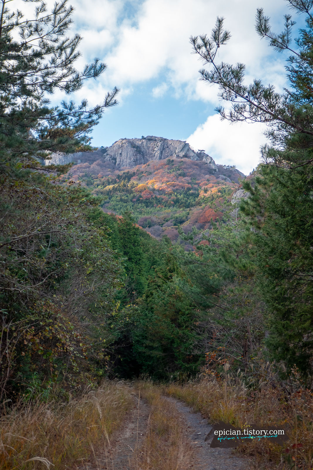 커다란 암릉 아래로 울긋불긋한 단풍이 보이는 풍경