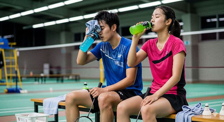 배드민턴 선수들이 훈련 후 스포츠 음료를 마시는 모습