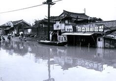 가게-간판만-보이고-도로에는-보트를-타고가는-사람들